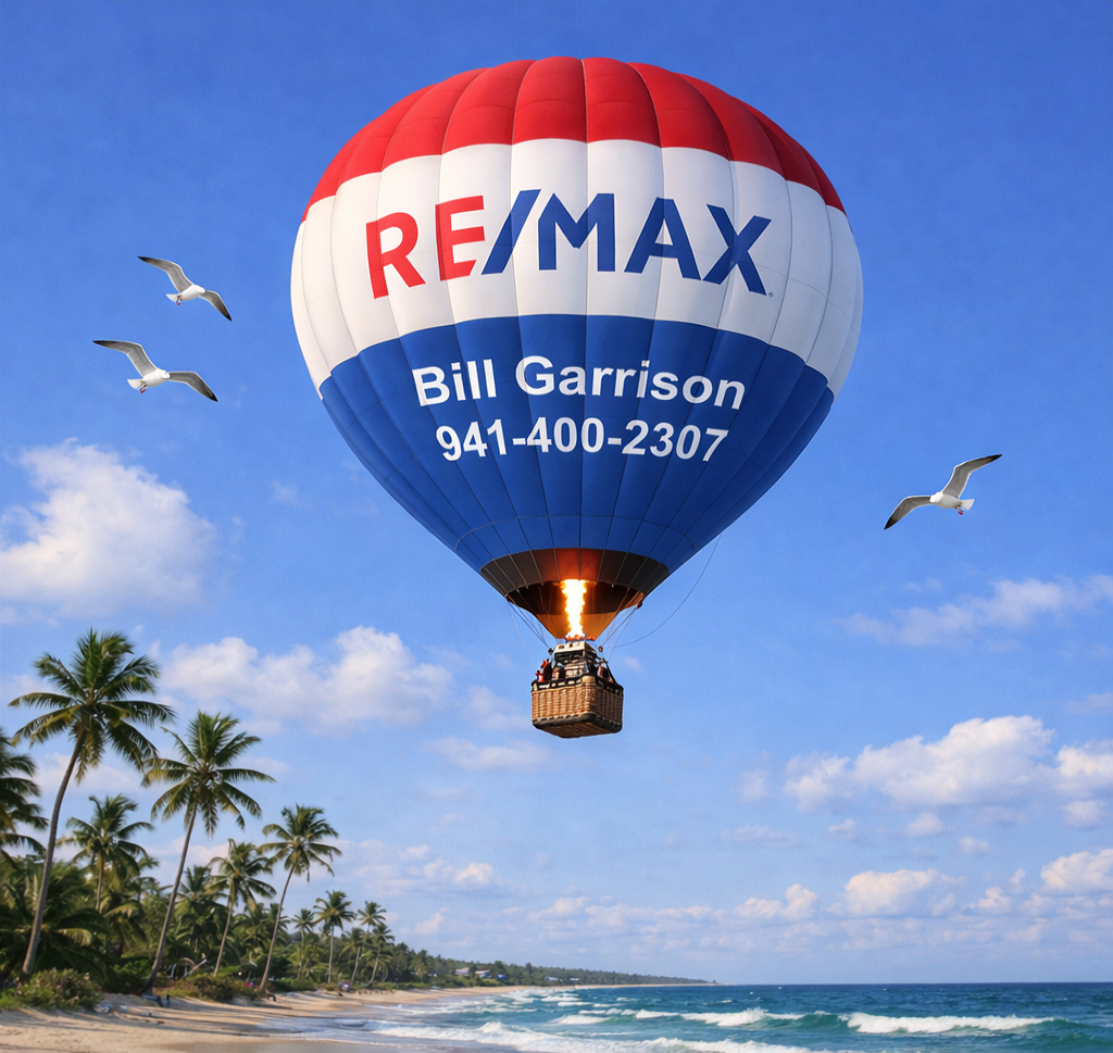 A colorful hot air balloon with the RE/MAX logo and a name displayed, flying over a scenic beach with palm trees and seagulls in the sky.