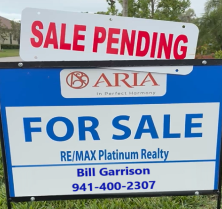 Real estate sign indicating 'Sale Pending' at a property, with 'For Sale' and contact information for RE/MAX Platinum Realty.